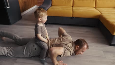 father happy playing with his son on the back at living room