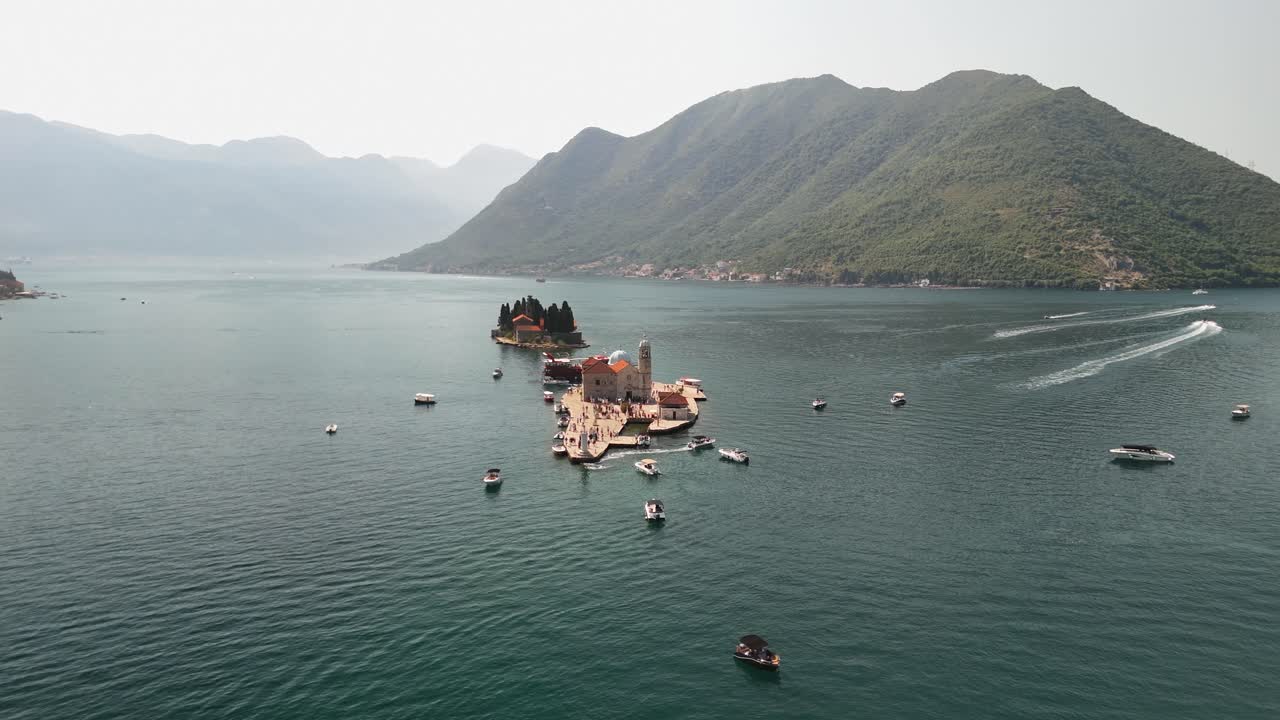 Low aerial slowly circles Our Lady of the Rocks island in Montenegro