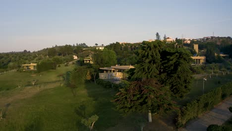 aerial view of rotation over the cork oak with a house lurking in alentejo, portugal. sunrise mode