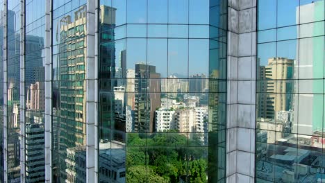 hong kong skyline reflecting off glass panels of a mega residential buildings, aerial view