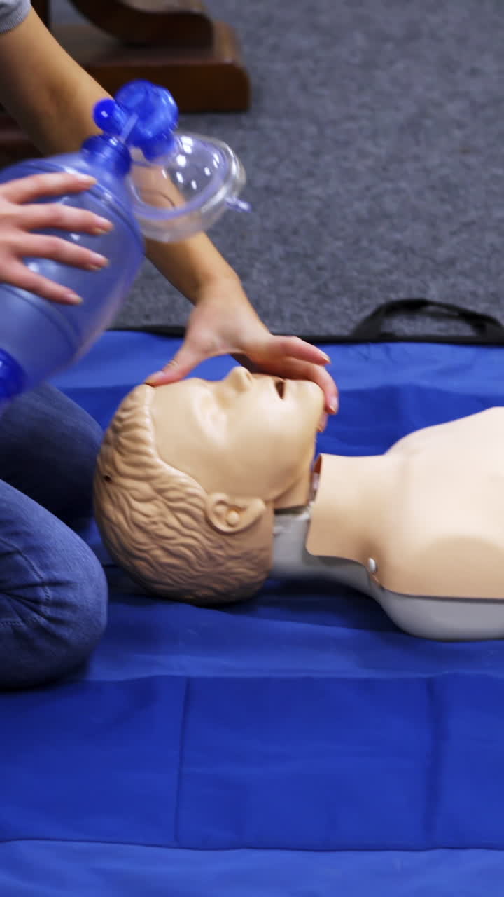 Training session for saving life. Instructor shows cardiac exercise on a mannequin. Demonstration of cpr on a dummy with breathing apparatus. Vertical video