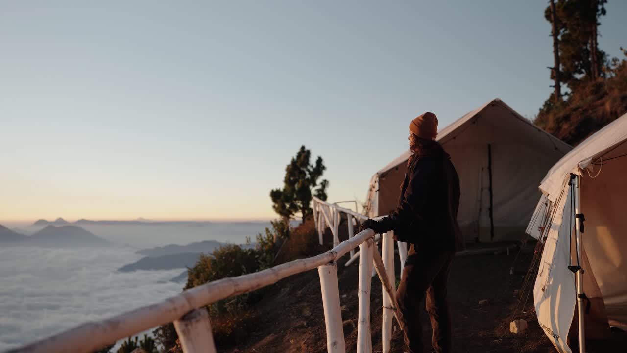 Escursionista che osserva l'alba al campo base del vulcano Acatenango in Guatemala.