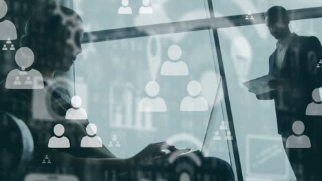 animation of digital icons over businesspeople using laptop and tablet