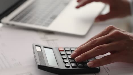 close up young woman using calculator, paying bills.