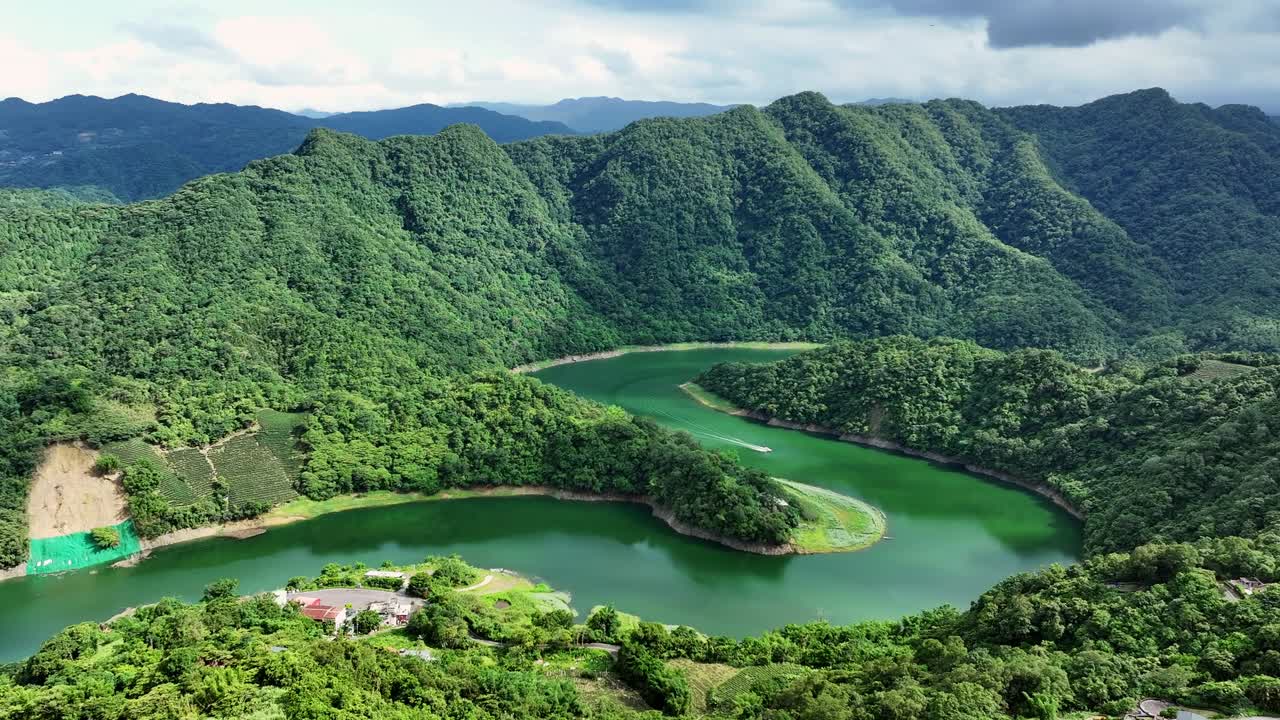 fotografía cinematográfica de un avión no tripulado que muestra el idílico embalse de feitsui con río verde y montañas cubiertas de vegetación en taiwán