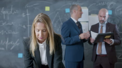 Happy-businesswoman-standing-at-table-and-working-on-computer