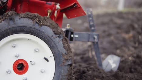 Close-Up-view-of-a-cultivator-tiller-preparing-garden-soil,-new-seeding-season-on-organic-home-vegetable-farm.-shot-in-Slow-Motion