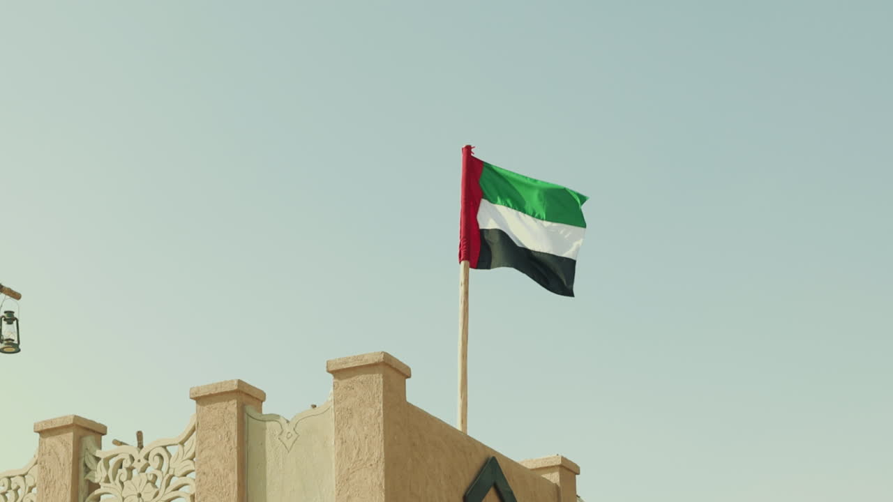 Bandiera nazionale degli Emirati Arabi Uniti con i colori rosso, verde, bianco e nero che sventola al vento.