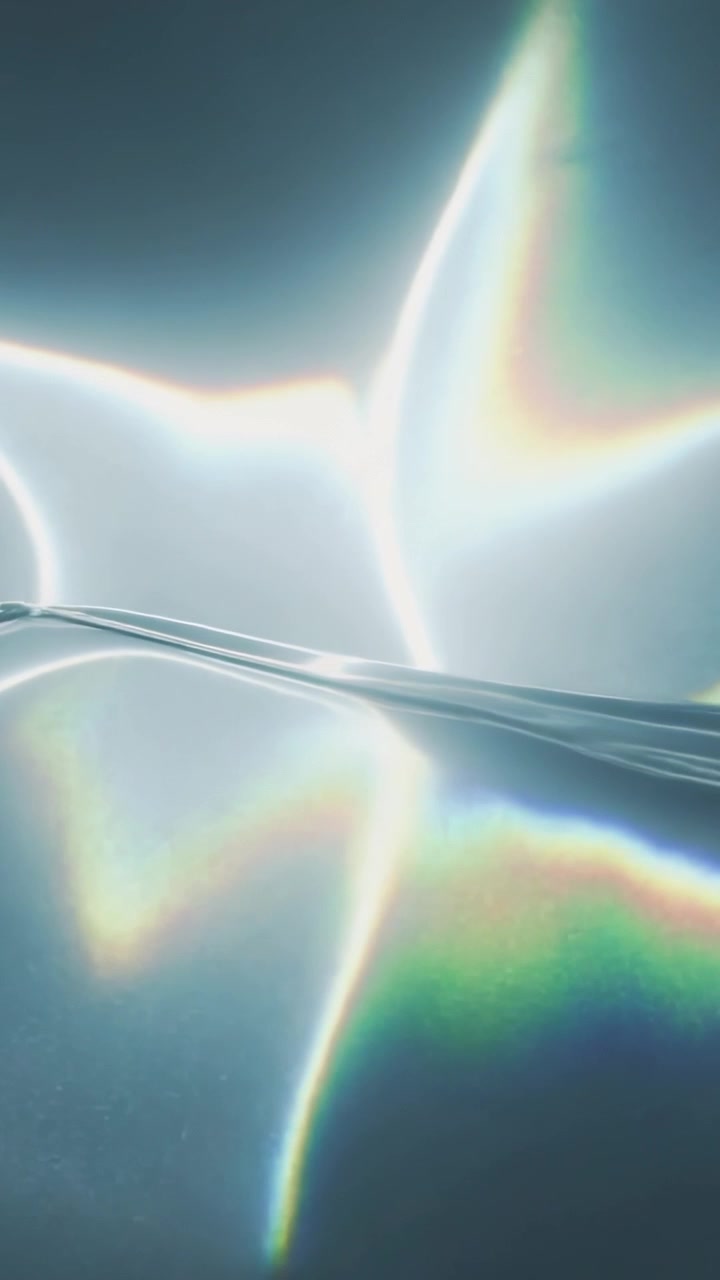 Vertical video: Seams glowing, sparking beam, glass ribbon shifting, casting prism hues for design