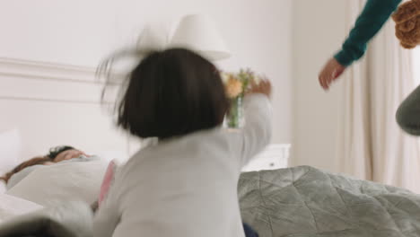 happy asian children jumping on bed waking up mother and father enjoying playful morning with kids on weekend at home 4k footage