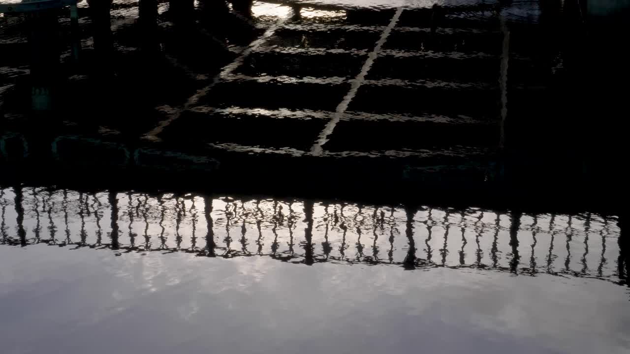 hermosos reflejos de agua de la silueta de la gente caminando en el paseo de la orilla del río, cámara lenta