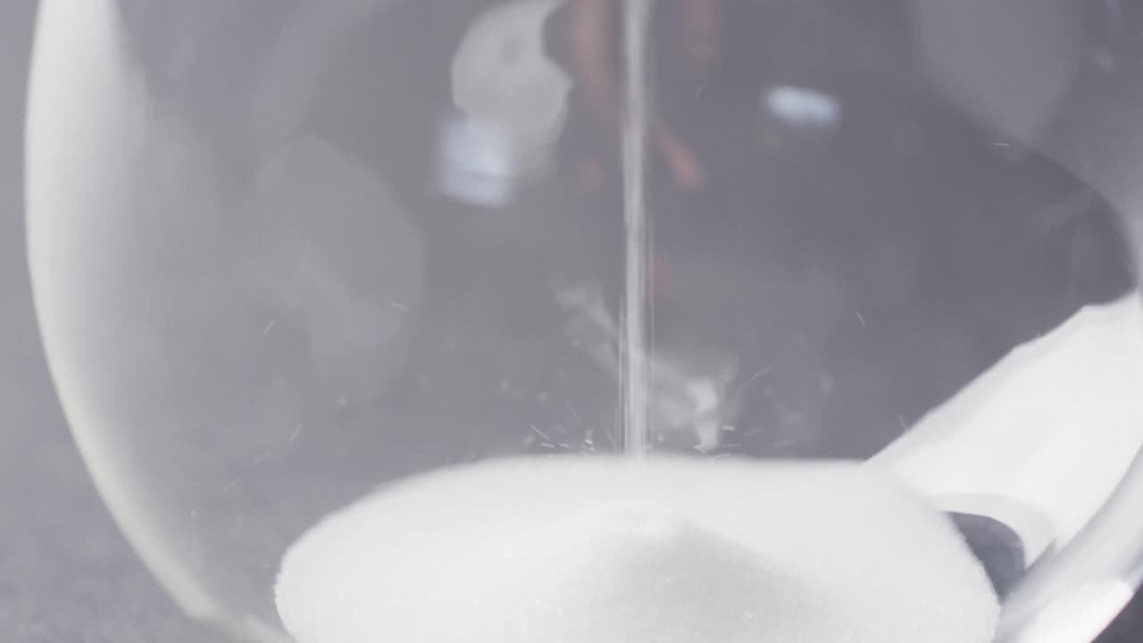 모래를  ⁇ 는 모래시계의 클로즈업 비디오, 검은 바탕에 공간을 복사