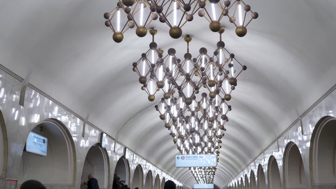This vibrant exploration showcases the stunning architecture of Moscow's metro stations, bustling with life as people navigate the beautiful corridors and stunning chandeliers.