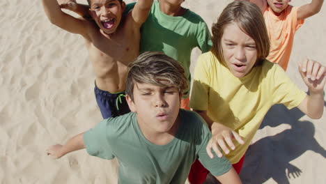 Shot-of-happy-kids-jumping-for-joy-on-beach-from-above