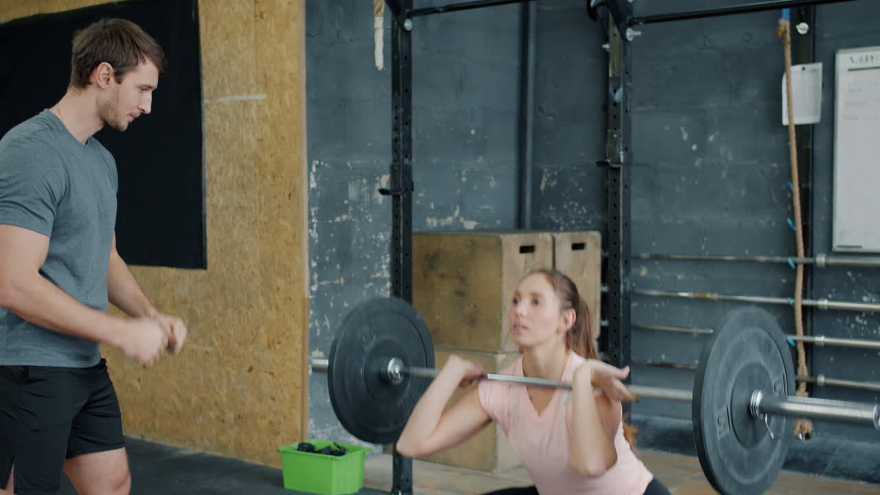 Woman Weightlifting with a Coach