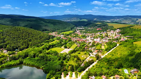 european village in nature. aerial view of a serene european village amid lush hills and fields, highlighting rural tranquility and beauty