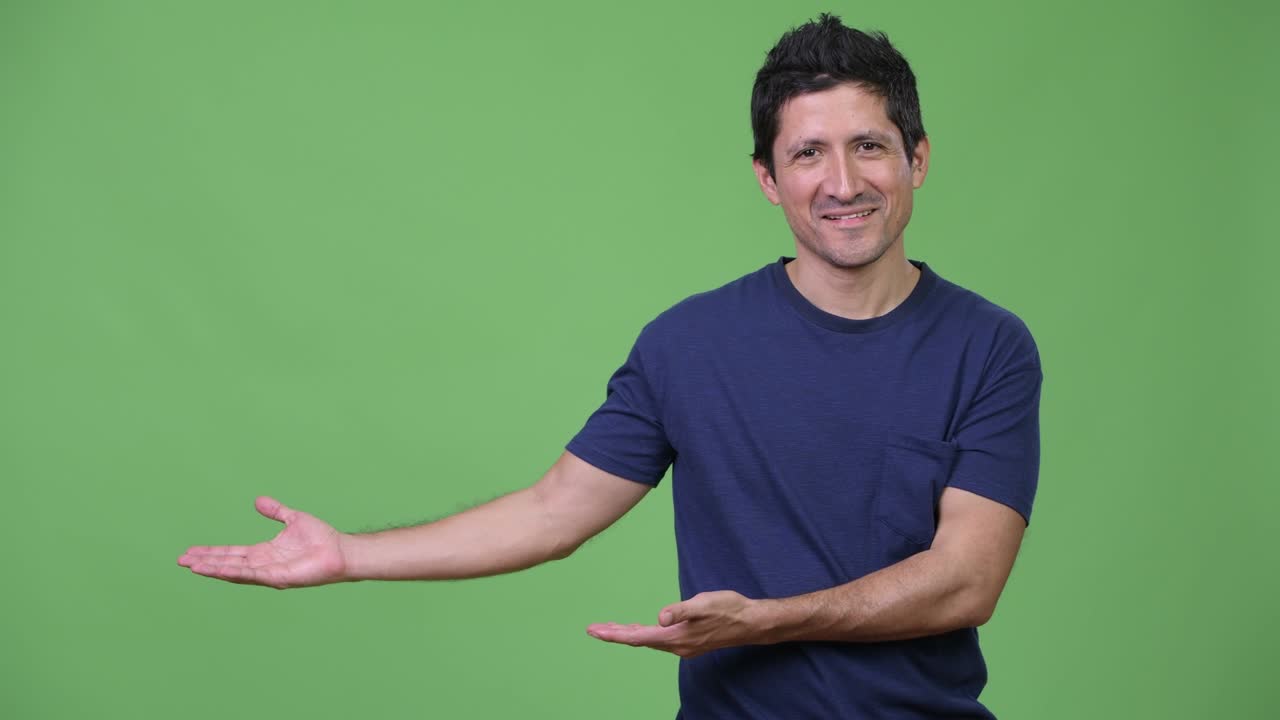 hombre hispano feliz mostrando algo