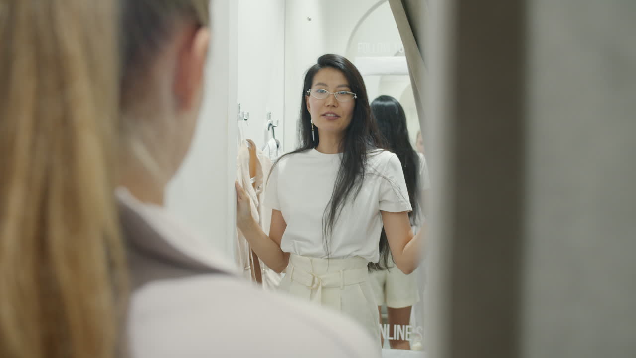 여자 가 착용실 에서 옷 을 착용 하고 있다