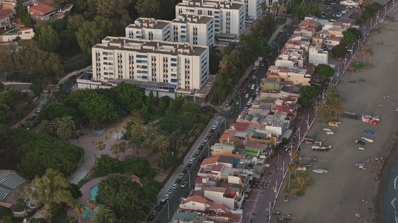 Malaga city beach with buildings and ocean from aerial perspective during sunset