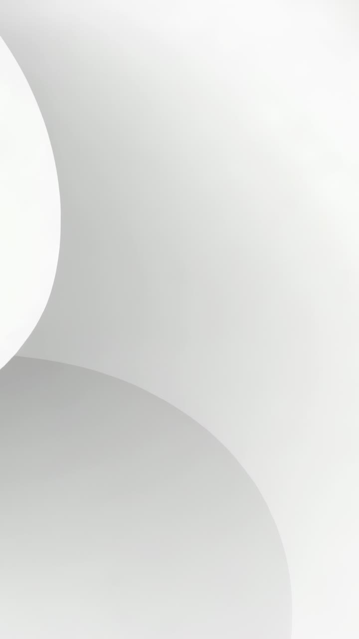 Vertical video: Sliding soft circles moving left into pale gray, revealing white circle, copy space