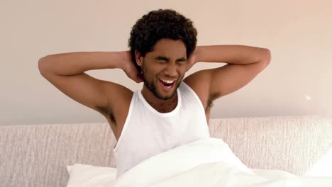 hombre despertando y estirándose en la cama