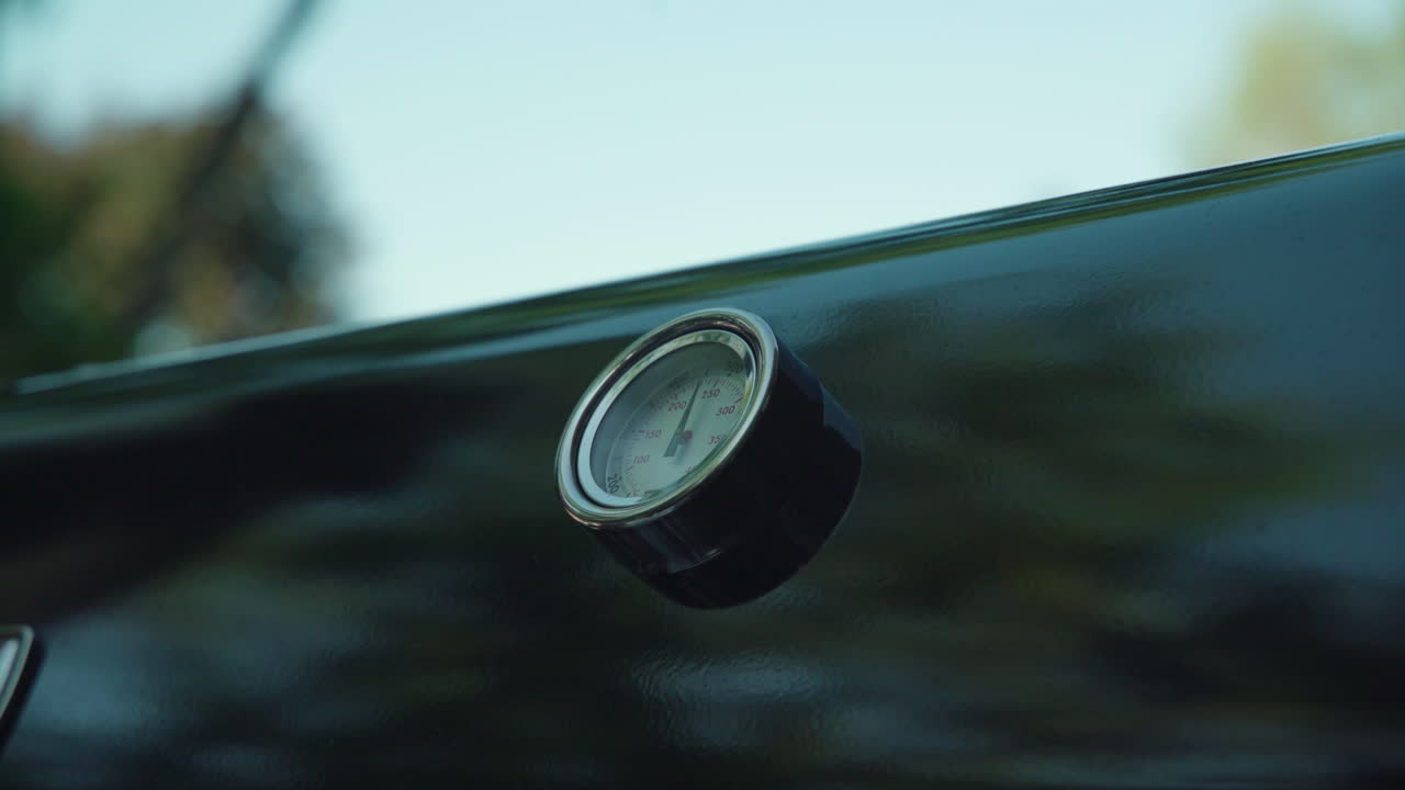 바비큐 뚜껑이 닫혀 온도계가 드러남