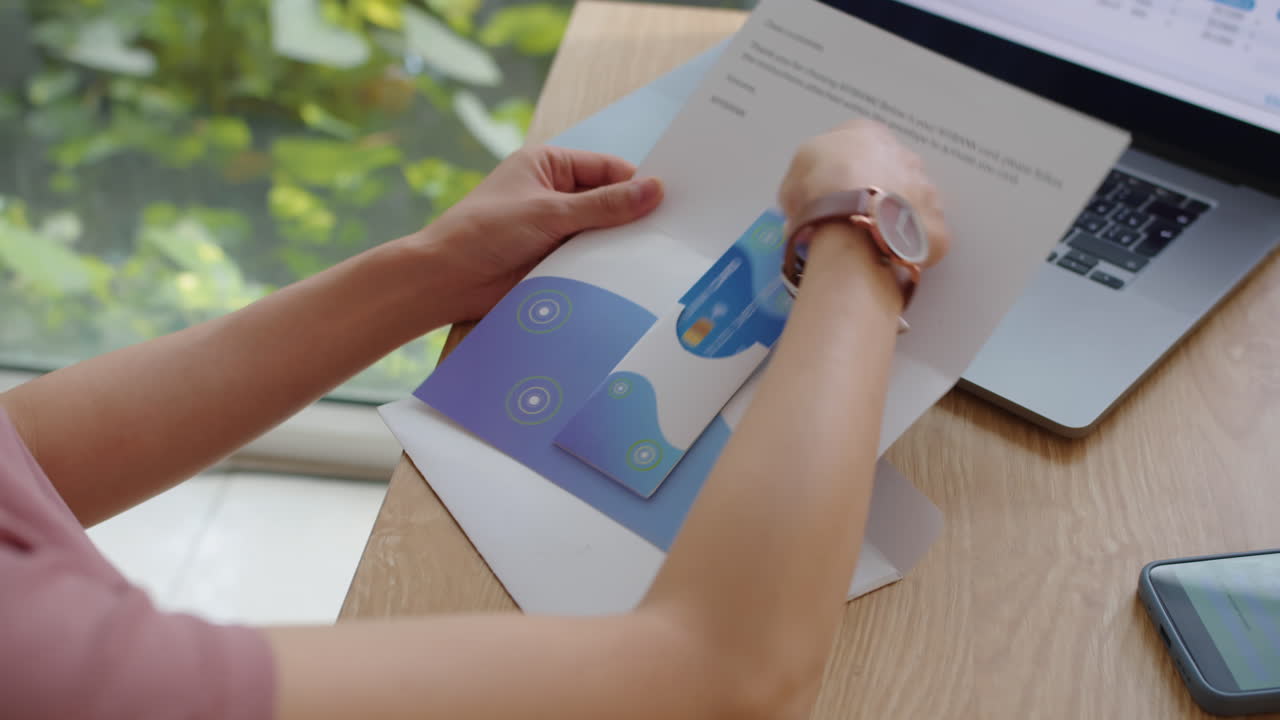 Hands of Woman Opening Envelope with Banking Card