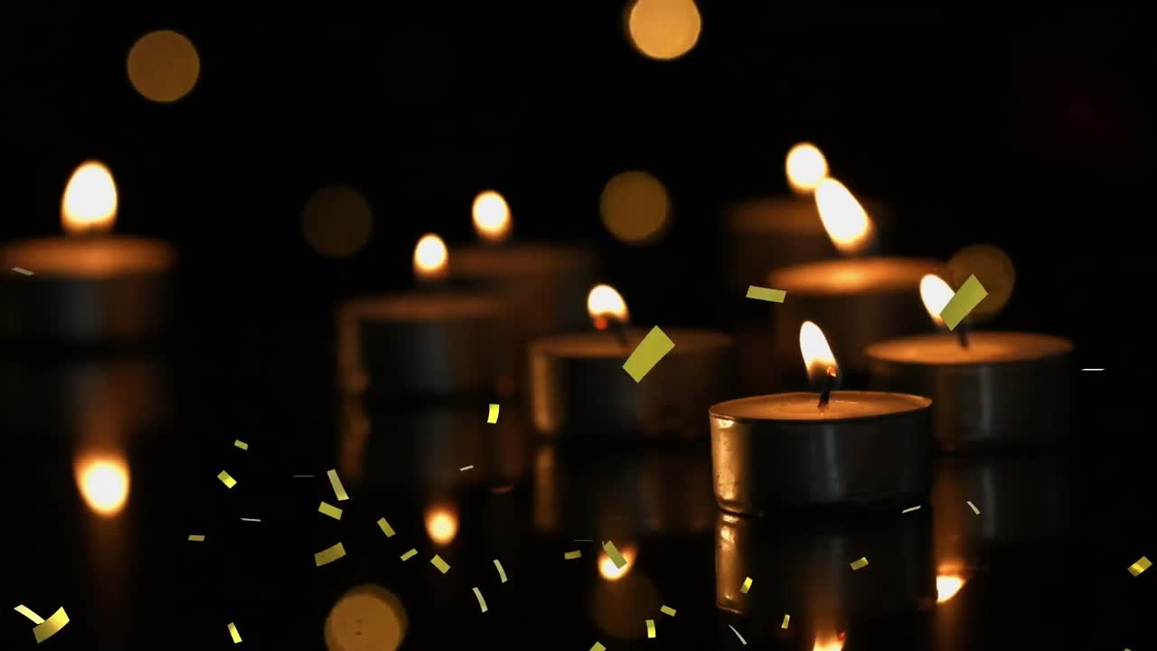 animación de confeti de oro que cae sobre velas de luz de té encendidas con luces bokeh y fondo oscuro