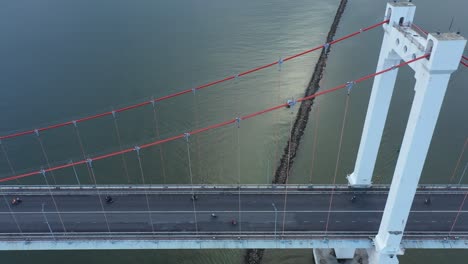 aerial tracking shot of thuan phuoc suspension bridge with traffic over river in danang, vietnam