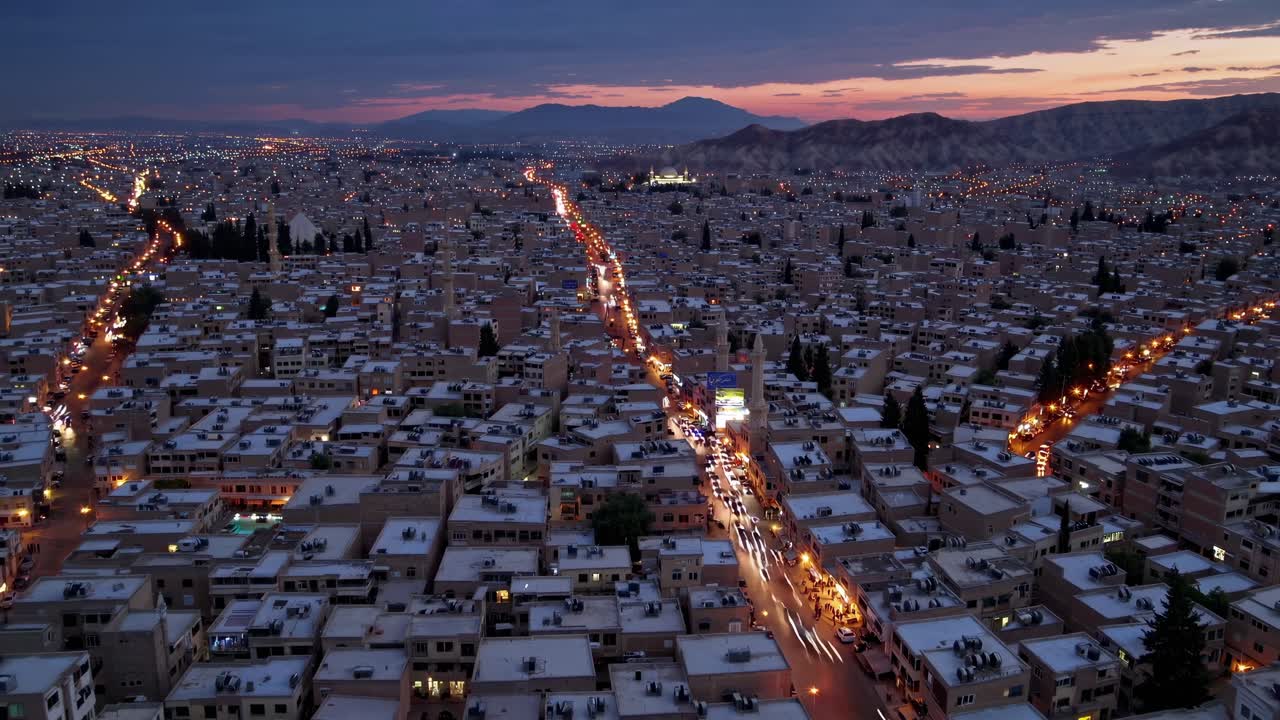 도시가 멀리까지 어나오며, 어두워지면서 거리 불빛의 따뜻한 빛에 비추어 도시 생활의 매혹적인 테이프를 만니다.