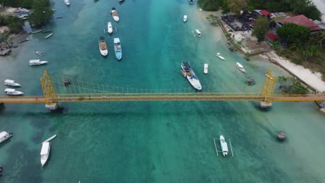 4K-Drohnenaufnahmen-Aus-Der-Luft:-Motorroller-überqueren-Die-Ikonische-Und-Malerische-Gelbe-Brücke,-Die-Die-Inseln-Nusa-Lembongan-Und-Nusa-Ceningan-Auf-Bali-Verbindet