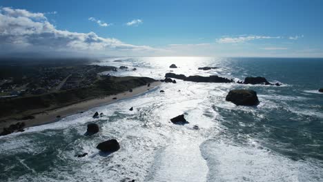 hermoso dron aéreo de 4k con cielos azules deslizándose sobre la playa de bandon en oregon en un día soleado