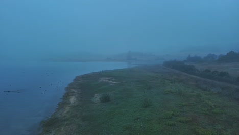 Misty-morning-by-the-lakeside-in-Nanclares-de-Gamboa,-Basque-Country,-Spain,-serene-and-tranquil