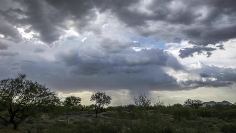 monsoon clouds march across a desert landscape dropping rain in the distance