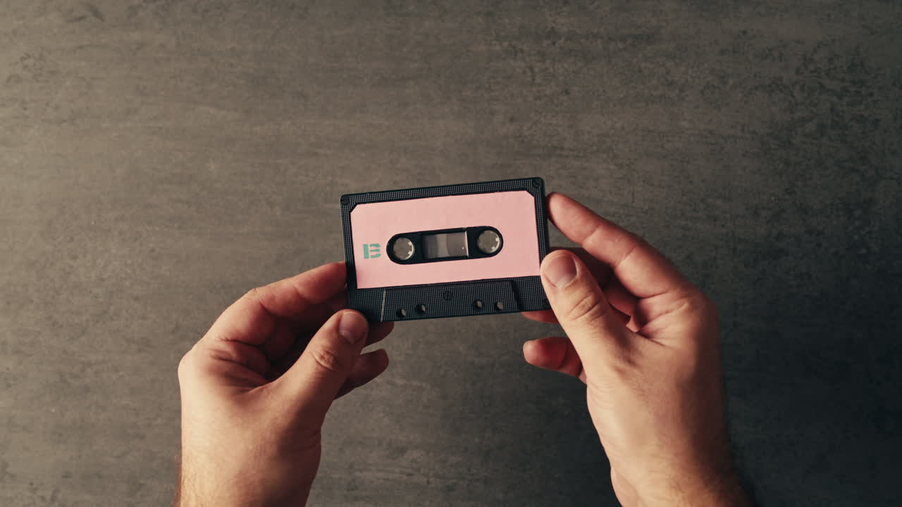 manos con una cinta de cassette antigua