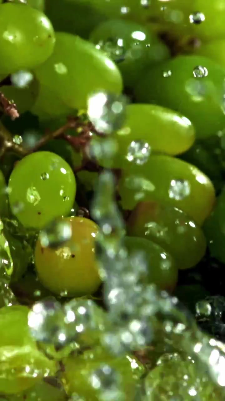 Uvas verdes frescas caindo e espirrando na água