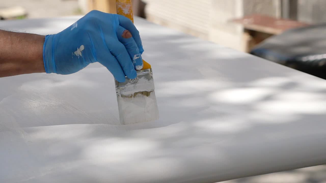 Painting a surface with a brush and white paint