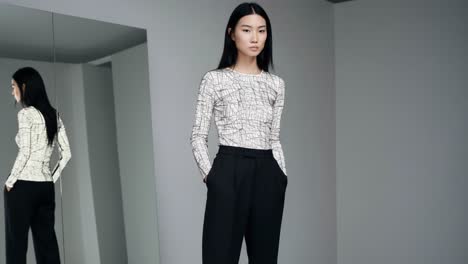 a fashionable model poses in a minimalistic environment, showcasing a stylish outfit with contemporary lines and textures reflecting modern aesthetics