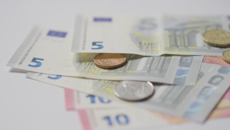 close up currency shot of hand counting euro notes and coins onto marble surface