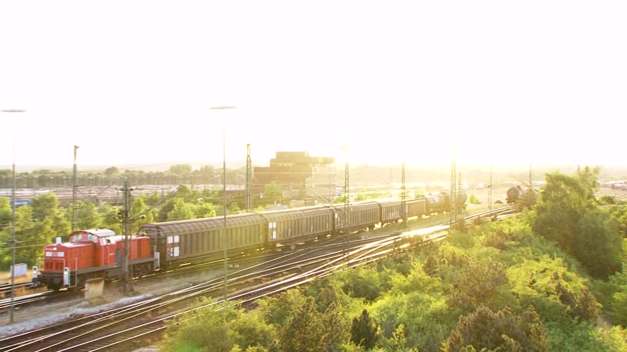 Bright train moves through lush greenery at sunset, calm and peaceful