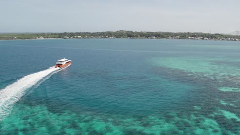 Cruise-ship-sailing-across-The-Caribbean-sea,-arriving-to-the-island-of-Utila,-Honduras---Aerial-footage