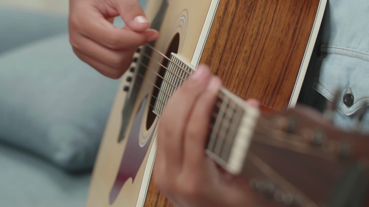 persona que toca la guitarra acústica