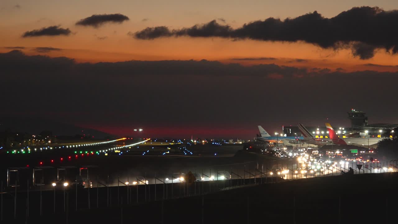 vista de un avión aterrizando en el aeropuerto de juan santa maría al anochecer