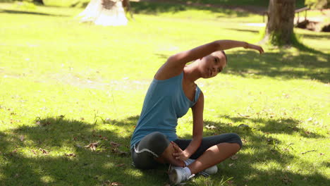 mujer en forma estirándose en el parque