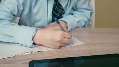 cu tracking schoolboy does homework writes a pen in a notebook uses a triangular ruler 1 on the table is a tablet