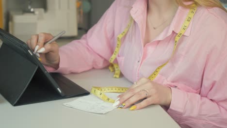 Female-Seamstress,-Tailor-using-tablet-to-make-measurements