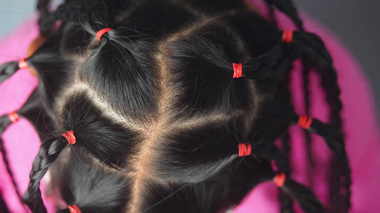 Braided hair with red hair ties