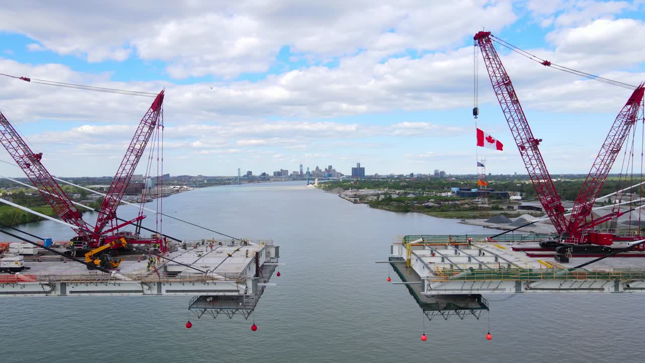 Cranes assembling Gordie Howe International Bridge deck over the Detroit River in final stage