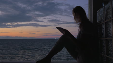 Mujer-Con-Tablet-Pc-En-El-Balcón-De-La-Casa-Junto-Al-Mar