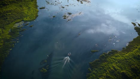 aerial view of a speed boat on the river parana with the sky mirrored in the river